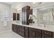 Spacious bathroom boasting a double vanity, dark wood cabinets, and bright lighting fixtures at 5142 N 205Th Gln, Buckeye, AZ 85396