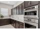 Gourmet kitchen features stainless steel appliances and dark wood cabinets at 5142 N 205Th Gln, Buckeye, AZ 85396