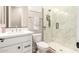 Contemporary bathroom with white vanity, marble tile shower, and glass enclosure at 5700 N 202Nd Ln, Litchfield Park, AZ 85340