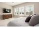 Well-lit bedroom with plantation shutters, a dresser with a tv, and plush bedding on a comfy bed at 5700 N 202Nd Ln, Litchfield Park, AZ 85340