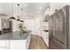 Modern kitchen with stainless steel appliances, white cabinets, a gray countertop island, and stylish pendant lighting at 5700 N 202Nd Ln, Litchfield Park, AZ 85340