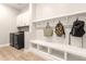 Mudroom with coat hooks, bench storage, and nearby washer/dryer at 5700 N 202Nd Ln, Litchfield Park, AZ 85340