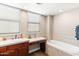 Bright bathroom featuring a built-in vanity and a tiled tub surround for a relaxing spa-like experience at 605 S Roosevelt St, Tempe, AZ 85281