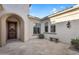 Entrance to a private courtyard featuring stone flooring, a bench, and an ornate, wooden front door at 610 W Tonto Dr, Chandler, AZ 85248