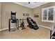 Exercise room with an exercise bike, massage chair, arcade game, and natural light from the window at 610 W Tonto Dr, Chandler, AZ 85248