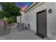 Exterior view showcases a gravel walkway leading to a side entrance door, accompanied by an HVAC system and verdant trees at 610 W Tonto Dr, Chandler, AZ 85248