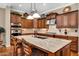 Spacious kitchen showcasing stainless steel appliances, an island with seating, and custom wood cabinets at 610 W Tonto Dr, Chandler, AZ 85248