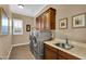 Well-lit laundry room with stainless steel washer and dryer, and cabinets at 610 W Tonto Dr, Chandler, AZ 85248