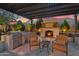 Outdoor kitchen area featuring a grill, seating, and stone fireplace, creating an ideal space for outdoor gatherings at 610 W Tonto Dr, Chandler, AZ 85248