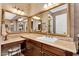 Bathroom vanity area with dual mirrors, marble countertops, dark wood cabinets, and a makeup vanity at 610 W Tonto Dr, Chandler, AZ 85248