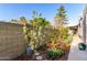 Well-maintained backyard featuring a young blossoming tree, vibrant flowers, and neat landscaping at 6338 E Camelot Dr, Mesa, AZ 85215