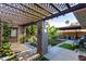 Lush backyard patio with a pergola, tropical plants, and a relaxing seating area, creating an inviting outdoor retreat at 6338 E Camelot Dr, Mesa, AZ 85215