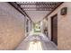 Picturesque courtyard featuring a pergola, textured stucco walls, and a tiled pathway leading to the main entrance at 6338 E Camelot Dr, Mesa, AZ 85215