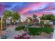 This inviting single-story home showcases a beautifully landscaped front yard, enhanced by vibrant plants and desert landscaping at 6338 E Camelot Dr, Mesa, AZ 85215