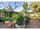 Backyard garden featuring metal raised beds, rock paths and mature trees at 6338 E Camelot Dr, Mesa, AZ 85215