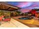 Backyard pool featuring colorful dusk sky, patio seating and covered gazebo with a hot tub at 6338 E Camelot Dr, Mesa, AZ 85215