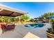 Backyard pool and patio area with lounge chairs, hot tub and lush landscaping at 6338 E Camelot Dr, Mesa, AZ 85215