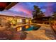 Backyard pool view with tranquil, colorful evening sky, seating and covered hot tub at 6338 E Camelot Dr, Mesa, AZ 85215