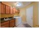 Functional laundry room equipped with cabinets, sink, washer, dryer, and exterior access door at 8715 S Valley Vista Ct, Casa Grande, AZ 85193