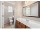 Bathroom featuring a white sink, cabinet, toilet, and a large framed mirror at 924 E Redondo Dr, Gilbert, AZ 85296