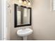 Elegant powder room with pedestal sink, modern fixtures and a framed mirror at 924 E Redondo Dr, Gilbert, AZ 85296