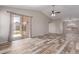 Spacious living room boasting wood-look flooring, ceiling fan, and sliding glass door at 9423 E Posada Ave, Mesa, AZ 85212