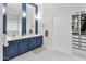 A bathroom featuring a blue-and-white color scheme, double sinks, and a walk-in closet at 10721 E Pampa Ave, Mesa, AZ 85212