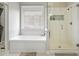 A bright bathroom featuring an alcove tub and a glass-enclosed shower at 10721 E Pampa Ave, Mesa, AZ 85212