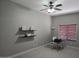 This bedroom offers neutral walls, two floating shelves, carpeted floor and a ceiling fan with a light fixture at 10721 E Pampa Ave, Mesa, AZ 85212