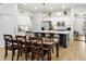 Dining area featuring a wooden table with seating, pendant lights, and a partial view of the kitchen with modern appliances at 10721 E Pampa Ave, Mesa, AZ 85212