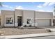 Contemporary single-story home featuring neutral stucco, rock landscaping, and a two-car garage, with a black front door at 10721 E Pampa Ave, Mesa, AZ 85212
