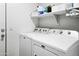 Clean laundry room with washer, dryer, shelving, and storage space at 10721 E Pampa Ave, Mesa, AZ 85212