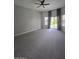 Bright living area with carpet, sliding doors to the backyard, and large windows for ample natural light at 10721 E Pampa Ave, Mesa, AZ 85212