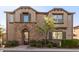 Charming two-story townhome featuring a stone facade, manicured landscaping, and a welcoming entrance at 1153 E Muirwood Dr, Phoenix, AZ 85048