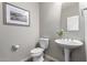 Charming powder room with pedestal sink, stylish mirror and decorative wall art at 1153 E Muirwood Dr, Phoenix, AZ 85048
