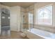 En suite bathroom with a glass-enclosed shower, soaking tub, and stained-glass window for added privacy at 1154 E Kramer Cir, Mesa, AZ 85203