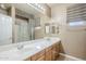 Neutral bathroom featuring double sinks, white countertops, framed mirror, and a shower with a decorative curtain at 1154 E Kramer Cir, Mesa, AZ 85203