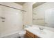 Clean and efficient bathroom with white fixtures, oak vanity and shower-tub combo at 1154 E Kramer Cir, Mesa, AZ 85203