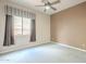 Cozy bedroom features a ceiling fan and a bright window with privacy blinds at 1154 E Kramer Cir, Mesa, AZ 85203