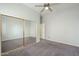 Clean bedroom with a ceiling fan, mirrored closet, and neutral gray carpet at 1154 E Kramer Cir, Mesa, AZ 85203