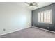 Minimal bedroom features a ceiling fan, gray accent wall, and shuttered window at 1154 E Kramer Cir, Mesa, AZ 85203
