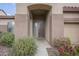 A brown front door to a house with decorative flowers and plants in the front yard at 1154 E Kramer Cir, Mesa, AZ 85203