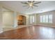 Bright and open living space with wood flooring, a ceiling fan, and a wall cutout to an office at 1154 E Kramer Cir, Mesa, AZ 85203