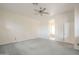 Main bedroom with plush carpet, ceiling fan, and arched doorway leading to an en suite bathroom at 1154 E Kramer Cir, Mesa, AZ 85203