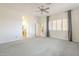 Bright main bedroom with neutral carpet, ceiling fan, and doorway to bathroom and walk-in closet at 1154 E Kramer Cir, Mesa, AZ 85203