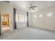 Main bedroom with plantation shutters, ceiling fan, and doorway leading to the en suite bathroom and vanity at 1154 E Kramer Cir, Mesa, AZ 85203