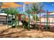 Community playground with green and orange climbing equipment and a slide at 12240 W Scotts Dr, El Mirage, AZ 85335