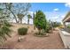 Large backyard with mature trees, desert landscaping and decorative elements at 12839 W Rincon Ct, Sun City West, AZ 85375