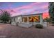 The home's backyard features desert landscaping and an inviting covered patio with multiple ceiling fans and seating at 12839 W Rincon Ct, Sun City West, AZ 85375