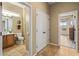 Bathroom with tiled floors and wood vanity with a door looking to another room creating a bright, functional space at 12839 W Rincon Ct, Sun City West, AZ 85375